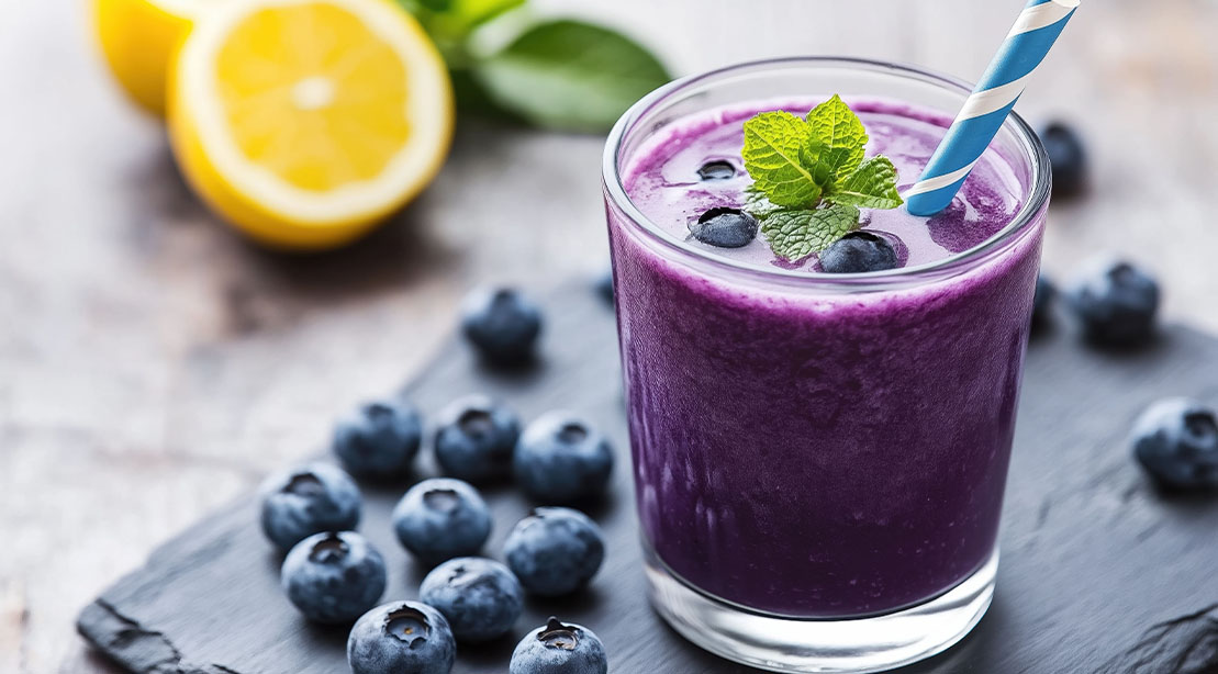 Lemon and blueberry smoothie garnished with a sprig of mint